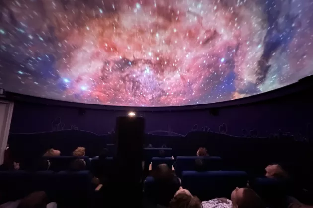 Audience watching a show in the Planetarium. Photo.