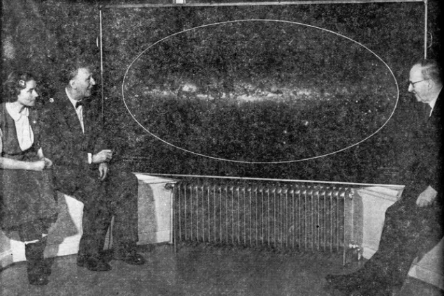 People sitting next to a painting 