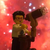 Lego Figure holding a lego telescope. Photo