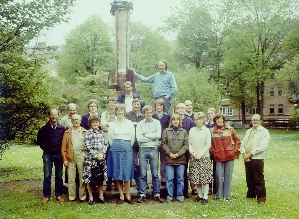 Astronomers in front of a statue