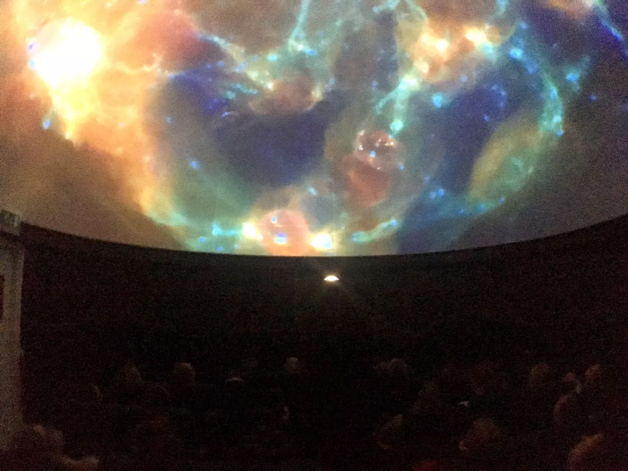 Audience in the planetarium watch a show. Photo.