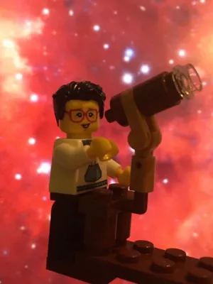Lego Figure holding a lego telescope. Photo